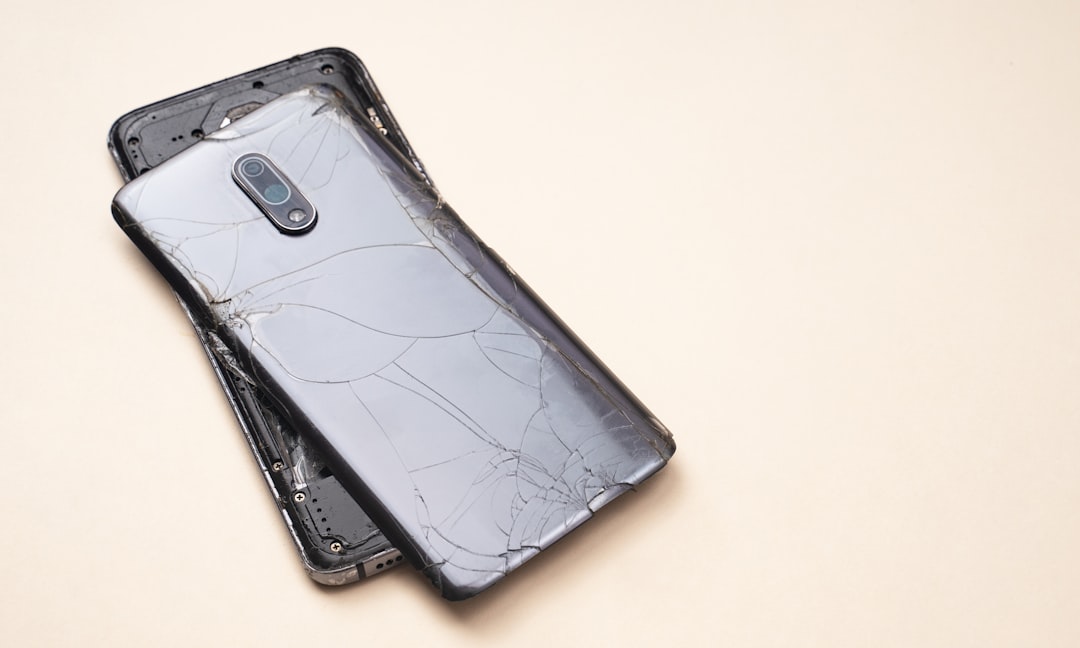 a-broken-cell-phone-laying-on-top-of-a-table-e6qlz0jufco